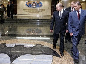 FILE In this file photo taken on Wednesday, Nov. 8, 2006, President Vladimir Putin, second right, and Russian President's special representative on questions of ecology and transport Sergei Ivanov, right, visit the Defense Ministry's Main Intelligence Directorate in Moscow, Russia. The Justice Department has announced charges against 12 Russian intelligence officers for hacking offenses during the 2016 presidential election, it was reported on Friday, July 13, 2018.