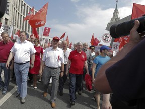 Communist Party leader Gennady Zyuganov, center, leads a march during a rally protesting retirement age hikes in Moscow, Russia, Saturday, July 28, 2018. Tens of thousands of demonstrators have rallied throughout Russia to protest plans to substantially hike the age at which Russian men and women can receive their state retirement pensions. (AP Photo)