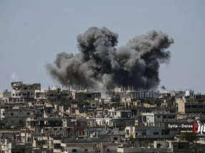 This Thursday, July 5, 2018 photo provided by Nabaa Media, a Syrian opposition media outlet, shows smoke rising over buildings that were hit by Syrian government forces bombardment, in Daraa province, southern Syria. Syrian state media and a war monitor say government forces have captured new areas along the border with Jordan and are on the verge of reaching a main crossing between the two countries. (Nabaa Media, via AP)