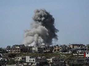 This Thursday, July 5, 2018 photo provided by Nabaa Media, a Syrian opposition media outlet, shows smoke rising over buildings that were hit by Syrian government forces bombardment, in Daraa province, southern Syria. Syrian state media and a war monitor said Friday that government forces have captured new areas along the border with Jordan and are on the verge of reaching a main crossing between the two countries. (Nabaa Media, via AP)
