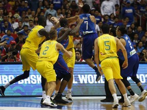 The Philippines' Jason William, centre, jumps to hit Australia's Daniel Kickert centre left as others rush to break the brawl during the FIBA World Cup Qualifiers Monday, July 2, 2018 at the Philippine Arena in suburban Bocaue township, Bulacan province north of Manila, Philippines. Australia defeated the Philippines 89-53 via default following a brawl in the third quarter.