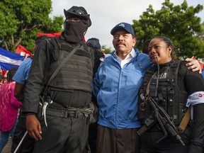 Nicaraguan police have their picture taken with President Daniel Ortega, in Masaya, Nicaragua, Friday, July 13, 2018. According to human rights groups, more than 300 person have been killed since April 19, since demonstrations erupted against the government of President Ortega. Most of them opponents of the regime.