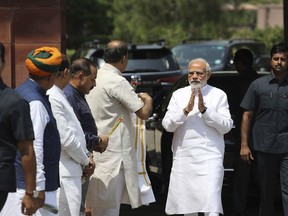 FILE - In this Wednesday, July 18, 2018 file photo, Indian Prime Minister Narendra Modi, second right, greets cabinet colleagues as he arrives on the opening day of the monsoon session of the Indian parliament in New Delhi, India. Congress party leader Rahul Gandhi on Friday accused the government of failing to live up to its promises as Parliament begins debating a no-confidence motion moved by the opposition against Prime Minister Narendra Modi's government.