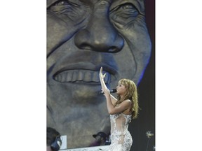 FILE - In this Nov. 2003 file photo, U.S. singer Beyonce Knowles performs at the Nelson Mandela, background, AIDS Benefit Concert in Cape Town, South Africa. It is announced Monday July 9, 2018, that Beyonce and Jay-Z will headline a special Global Citizen Festival in South Africa to honor Mandela as part of events marking the 100th anniversary of the birth of the anti-apartheid leader and Nobel Peace Prize winner.