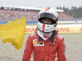 Ferrari driver Sebastian Vettel of Germany walks back to his pits after he crashed into the track wall during the German Formula One Grand Prix at the Hockenheimring racetrack in Hockenheim, Germany, Sunday, July 22, 2018.