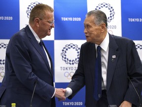 John Coates, left, chairman of the IOC Coordination Commission for the 2020 Tokyo Olympics and Paralympics, and Tokyo Olympic organizing committee President Yoshiro Mori, right, shake hands after the IOC and Tokyo 2020 joint press conference in Tokyo Thursday, July 12, 2018.
