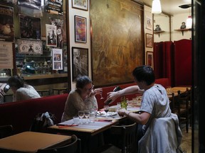 In this photo taken on Monday, June 25, 2018, a couple attend a romantic diner at "La Cave a Jojo" restaurant in Montmartre district, in Paris. Paris' bistros and terraces have formed an association of bistros owners to launch a campaign to be recognized by the United Nations' cultural agency UNESCO as a French way of life with  "intangible cultural heritage" status.