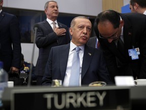 Turkish President Recep Tayyip Erdogan listens to his special adviser Ibrahim Kalin prior to a working session of a NATO summit of heads of state and government in Brussels on Thursday, July 12, 2018.