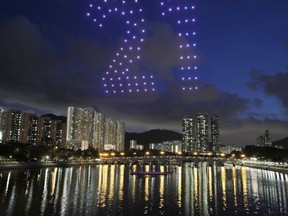 One hundred drones are remote-controlled to form a shape of number 21 in Hong Kong, Saturday, June 30, 2018, to celebrate the upcoming 21st anniversary of the city's return to Chinese sovereignty from British rule on July 1.