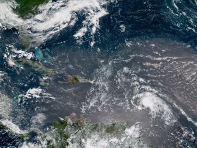 In this geocolor image GOES-16 satellite image taken Sunday, July 8, 2018, at 15:00 UTC, shows Tropical Storm Beryl, center right, moving across the Lesser Antilles in the eastern Caribbean Sea, and Tropical Storm Chris, top left, off the U.S. East Coast. (NOAA via AP)