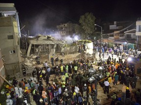 FILE - In this Sept. 19, 2017 file photo, volunteers and rescue workers search for children trapped inside at the collapsed Enrique Rebsamen school where 37 people died in Mexico City. Mexican police said Sunday, July 22, 2018 they have arrested the construction supervisor who oversaw work at the elementary school and will charged him with homicide.