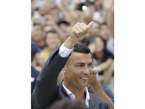 Portuguese ace Ronaldo salutes his fans as he arrives to undergo medical checks at the Juventus stadium in Turin, Italy, Monday, July 16, 2018.