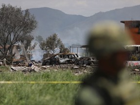 A soldier stands next to the wreckage of several fireworks workshops in Tultepec, Thursday, July 5, 2018. More than a dozen people were killed and at least 40 injured  when a series of explosions ripped through fireworks workshops in a town just north of Mexico City.