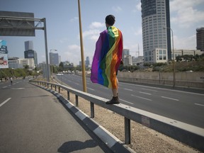 LGBTQ community members block a highway during a protest against a surrogate bill in Tel Aviv, Israel, Sunday, July 22, 2018.