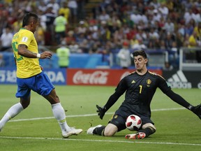 Belgium goalkeeper Thibaut Courtois, right, makes a save as Brazil's Paulinho tries to score during the quarterfinal match between Brazil and Belgium at the 2018 soccer World Cup in the Kazan Arena, in Kazan, Russia, Friday, July 6, 2018.