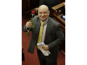 Carlos Lozada, a former member of the demobilized Revolutionary Armed Forces of Colombia, FARC, shows a red rose upon his arrival to Congress to take up a seat as a Senator of the newly-elected legislature, in Bogota, Colombia, Friday, July 20, 2018. Under the terms of the 2016 peace deal ten seats are guaranteed to former rebels in Congress.