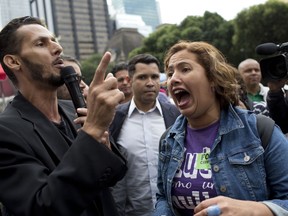 A supporter of Rio Mayor Marcelo Crivella, left, argues with an opposition demonstrator in front of City Hall in Rio de Janeiro, Brazil, Thursday, July 12, 2018. Rio's city council will analyze two impeachment processes against Crivella who is accused of using his position to benefit members of the Evangelical church.