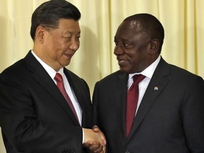 South African President Cyril Ramaphosa, right, shakes hand with Chinese President Xi Jinping after a joint press conference at the government's Union Buildings in Pretoria, South Africa, Tuesday, July 24, 2018. Jinping is in the country to attend the three-day BRICS Summit starting Wednesday in Johannesburg.