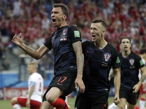 Croatia's Mario Mandzukic, left, celebrates with his teammates after scoring the opening goal of his team during the round of 16 match between Croatia and Denmark at the 2018 soccer World Cup in the Nizhny Novgorod Stadium, in Nizhny Novgorod, Russia, Saturday, July 1, 2018.