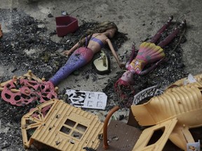 In this Thursday, July 26, 2018 photo, burnt dolls lie in a yard of a destroyed house in Mati east of Athens. More than 86 people were either killed by the flames or drowned on Monday's wildfire as they tried to flee the fire into the nearby sea, waiting for hours in the water for rescue from local fishermen and private boat owners who saved many.