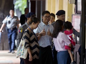 Reuters journalist Wa Lone, center, thumbs up as he walks along with his pregnant wife Pan Ei Mon upon arrival for his trial in Yangon, Myanmar Monday, July 30, 2018. Wa Lone and Kyaw Soe Oo are accused of illegally possessing official information.