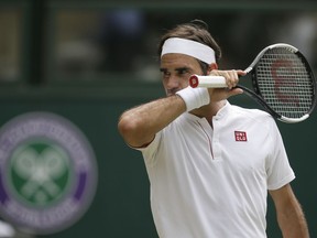 Roger Federer of Switzerland wipes his face during his men's singles match against France's Adrian Mannarino, on day seven of the Wimbledon Tennis Championships, in London, Monday July 9, 2018.