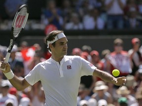 Roger Federer of Switzerland sends a ball into the tribunes after defeating Serbia's Dusan Lajovic, in their Men's Singles first round match at the Wimbledon Tennis Championships in London, Monday July 2, 2018.