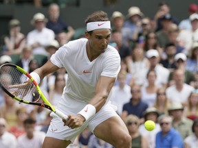 Rafael Nadal of Spain returns the ball to Mikhail Kukushkin of Kazakhstan, during their men's singles match, on the fourth day of the Wimbledon Tennis Championships in London, Thursday July 5, 2018.