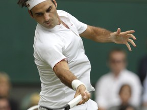 Switzerland's Roger Federer returns the ball to Slovakia's Lukas Lacko during their men's singles match, on the third day of the Wimbledon Tennis Championships in London, Wednesday July 4, 2018.