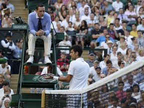 Serbia's Novak Djokovic complains to the umpire during his men's singles match against Kyle Edmund of Great Britain, on the sixth day of the Wimbledon Tennis Championships in London, Saturday July 7, 2018.