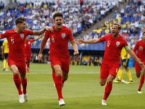 England's Harry Maguire, center, celebrates with his teammates after scoring his side opening goal during the quarterfinal match between Sweden and England at the 2018 soccer World Cup in the Samara Arena, in Samara, Russia, Saturday, July 7, 2018.