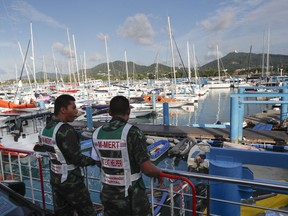 Thai rescuers watch from Chalong pier in Phuket, Thailand, Saturday, July 7, 2018, a day after a boat accident. Thai authorities on Friday evening suspended the search for missing tourists who were on the boat that sank during a storm off the southern resort island of Phuket.