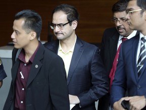 Riza Aziz, center, stepson of Malaysian former Prime Minister Najib Razak, arrives at Anti-Corruption Agency in Putrajaya, Malaysia, Tuesday, July 3, 2018. Riza appears before the Malaysian Anti-Corruption Commission to give statement related to the 1MDB investigation.