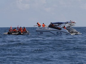 Thai rescue divers and a tourist police boat are seen during a search mission for missing passengers from a capsized tourist boat in the water off Phuket, Thailand, Saturday, July 7, 2018. A search resumed for some 23 missing tourists on a boat that sank during a storm off the southern resort island of Phuket.