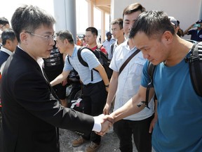 Chinese Ambassador Lyu Jian, left, greets Chinese divers before sending them off to join a search mission for missing passengers from a capsized tourist boat in the water off Phuket, Thailand, Saturday, July 7, 2018. A search resumed for some 23 missing tourists on a boat that sank during a storm off the southern resort island of Phuket.