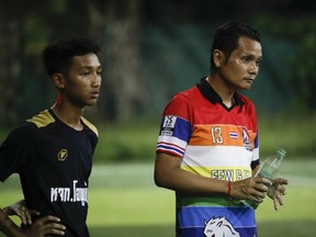In this July 15, 2018, photo, the coach of one of Thailand's Wild Boars soccer teams, Nopparat Kanthawong, right, watches his team play in Mae Sai district in Chiang Rai province, northern Thailand. At least 3 of the 12 boys and coach of another local team who were rescued from a cave in northern Thailand last week are stateless, living in a limbo that puts serious restrictions not only on their upward mobility, but even on their right to travel outside of Chiang Rai, the northern province where they live.