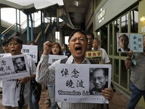 Protesters hold placards with picture of late Chinese Nobel Peace laureate Liu Xiaobo during a protest in Hong Kong, Friday, July 13, 2018, to mark the first death anniversary of China's most prominent political prisoner, and Nobel Peace Prize laureate.
