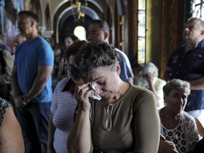 Orthodox faithful attend a memorial service for the victims of a forest fire, inside a church at Mati village, east of Athens, Sunday, July 29, 2018. Hundreds of worshippers attended a memorial service in Mati for the dozens who perished in a wildfire that devastated the seaside resort.
