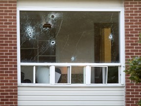 Bullet holes riddle a window in an apartment building in Fredericton on Friday, Aug. 10, 2018.