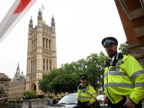 Police officers secure the roads around the Houses of Parliament as forensic teams continue their work around a vehicle after it crashed into security barriers, injuring a number of pedestrians, outside the Houses of Parliament on August 14, 2018 in London, England.