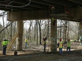 A construction crew works under the I-95/495 outer loop bridge over Suitland Parkway April 13, 2015 in Forestville, Maryland.