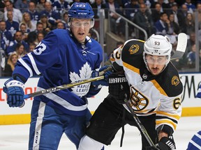 In this April 23 file photo, Toronto Maple Leafs defenceman Travis Dermott (left) battles with Boston Bruins forward Brad Marchand in the first round of the playoffs.