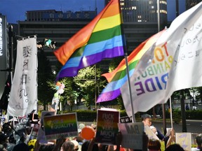 In the July 27, 2018 photo, people protest in front of ruling Liberal Democratic Party headquarters in Tokyo against lawmaker Mio Sugita.  Japanese activists including seven parents of LGBT children have submitted a petition with more than 25,000 signatures to Prime Minister Shinzo Abe’s party, demanding that the lawmaker apologize for saying that sexual minorities are unproductive and don’t deserve public support.