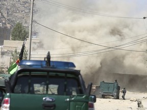 Smoke rises from a house where suspected attackers are hiding in Kabul, Afghanistan, Tuesday, Aug. 21, 2018.