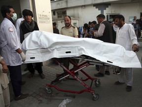 Afghans carry the body of a man who was killed in a deadly suicide bombing that targeted a training class in a private building in the Shiite neighbourhood of Dasht-i Barcha, in western Kabul, Afghanistan, Wednesday, Aug. 15, 2018.