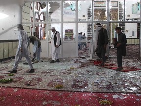 Afghan residents walk inside a damaged mosque after a suicide attack during Friday prayers in Gardez of Paktia province on August 3, 2018.  Burqa-clad suicide bombers struck a Shiite mosque in eastern Afghanistan Friday as it was crowded with worshippers for weekly prayers, killing at least 29 people and wounding more than 80 in the latest attack on the minority.