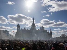 In this file photo taken on April 20, 2018 smoke lingers over Parliament Hill as people smoke marijuana during the annual 4/20 rally on Parliament Hill in Ottawa.