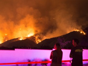 People watch flames from the Holy Fire outside Glen Ivy Hot Springs in Corona, California, southeast of Los Angeles, on August 10, 2018.
