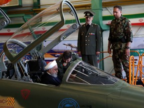 A handout picture released by the Iranian Presidency on August 21, 2018, shows President Hassan Rouhani sitting in the cockpit of the "Kowsar" domestic fighter jet.