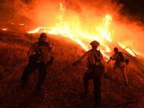 In this file photo taken on August 1, 2018, firefighters conduct a controlled burn to defend houses against flames from the Ranch Fire, part of the Mendocino Complex Fire, as it continues to spreads towards the town of Upper Lake, California.